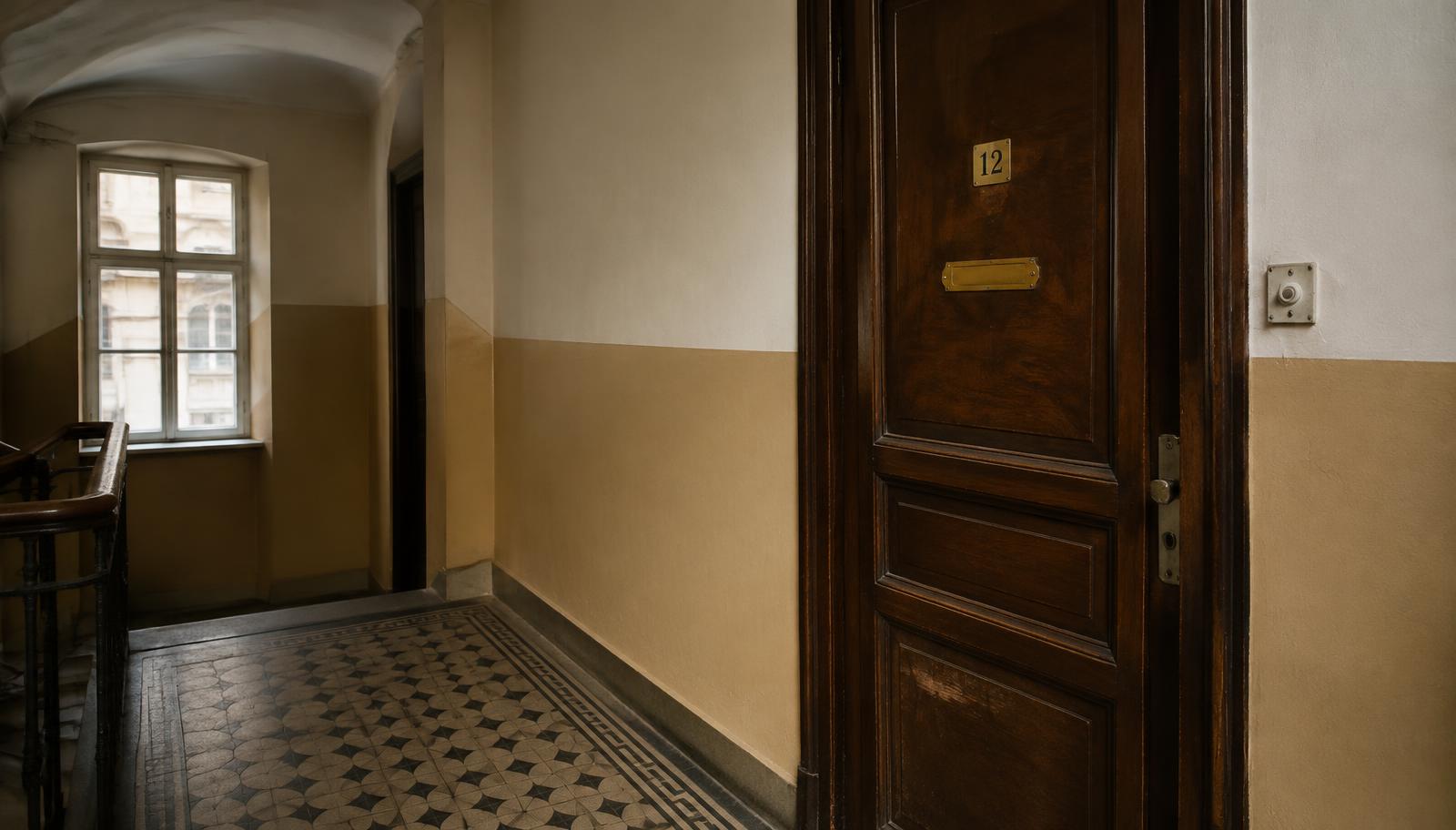 Dveře bytu na chodbě pražského činžáku